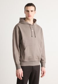 Sudadera con capucha en mezcla de algodón color topo, con un bolsillo canguro, cordones ajustables y un logo sutil en el pecho.