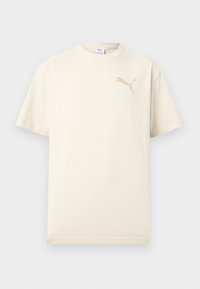 Κοντομάνικο κρεμ μπλουζάκι με μπεζ λογότυπο Puma στο πάνω αριστερό μέρος του στήθους και στρογγυλή λαιμόκοψη, εμφανίζεται σε απλό φωτεινό φόντο.