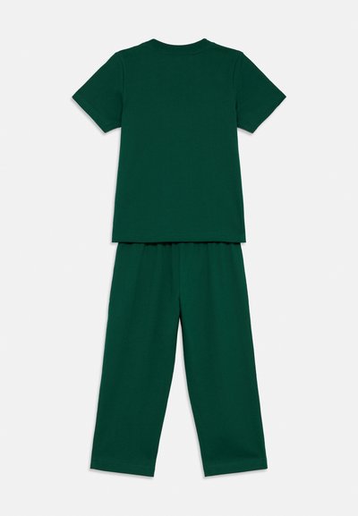 Das grüne Baumwoll-Zweiteiler-Set umfasst ein T-Shirt mit kurzen Ärmeln und eine lockere Hose mit elastischem Bund. Glatte Textur, schlichtes Design.