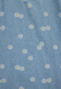 Jasnoniebieska tkanina z rozmieszczonymi nieregularnie małymi białymi stokrotkami o żółtych środkach.