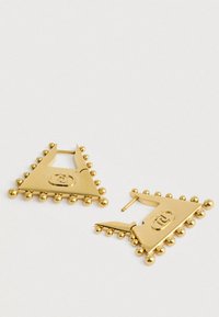 Χρυσά τριγωνικά σκουλαρίκια με στρογγυλεμένες άκρες, διακοσμημένα με μικρούς σφαιρικούς εκφορτίες κατά μήκος της περιφέρειας και με λογότυπο στο κέντρο.