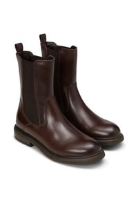Bottes chevilles en cuir marron avec des panneaux élastiques sur les côtés, des bouts ronds et des semelles texturées. Comprend des sangles pour un enfilage facile.