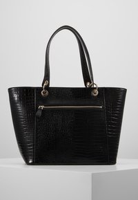 Sac cabas noir en simili-crocodile avec doubles poignées, poche zippée à l'avant et ferrures dorées. Texture lisse et forme structurée.
