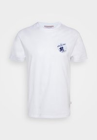 T-shirt blanc à manches courtes avec un petit graphisme bleu représentant une personne à vélo et le texte "over the moon" sur la zone de la poche poitrine.