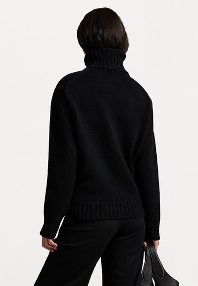 Maglione nero lavorato a maglia con un alto colletto a coste, con maniche lunghe e orlo a coste. La texture sembra morbida e voluminoso.