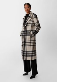 Beige- und schwarzer Mantel mit Karomuster aus Wollmischung; verfügt über breite Revers, lange Ärmel, zwei seitliche Taschen und einen knielangen Schnitt.