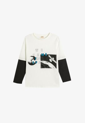 Biały i czarny t-shirt z długim rękawem. Posiada graficzny nadruk z napisem „PRZYBYLIŚMY Z KOSMOSU”, z wizualizacją Ziemi i satelity. Wykonany z materiału bawełnianego.