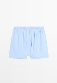 Boxer in cotone azzurro chiaro con elastico in vita, caratterizzati da una vestibilità ampia e una texture liscia. Design semplice senza motivi o accenti.