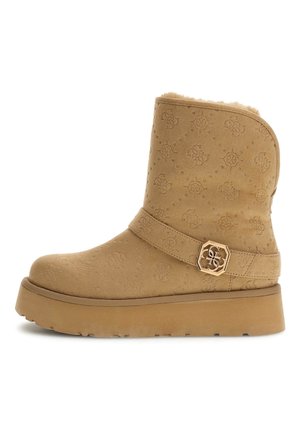 Tan suède enkellaars met geperste patroon, bontvoering, brede band met gouden hexagonale hardware-accent en dikke platformzool.