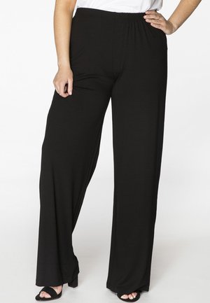 Zwarte, wijde broek gemaakt van zachte, rekbare stof met een elastische tailleband. Kenmerkt zich door een gladde textuur en een lengte tot de volledige enkel.