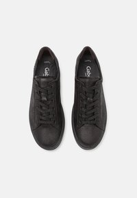 Baskets en cuir noir avec une finition texturée, design à lacets, bout arrondi et doublure intérieure douce avec un logo sur la semelle intérieure.