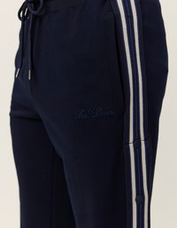 Námornícke tepláky so bočnými pruhmi v modrej a béžovej farbe, s vyšívaným logom, nastaviteľným pásom na šnúrku a cvokovými doplnkami.