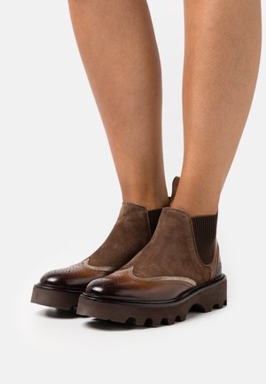 Braune Leder- und Wildleder-Chelsea-Boots mit einer strukturierten Oberfläche, elastischen Seitenpanelen und einer dicken, geriffelten Sohle mit dekorativen Broguedetails.