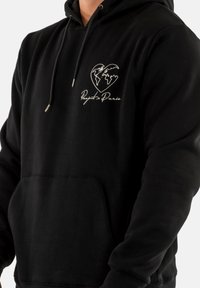 Hoodie noir avec un design en forme de cœur représentant un globe et un texte brodé "Project Paris". Comprend une poche avant et un capuchon à cordon.