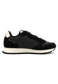 Sneaker bassa bianca e nera con lacci neri, suola bianca, pannelli in pelle scamosciata e pelle, e dettaglio cucito vicino al tallone.