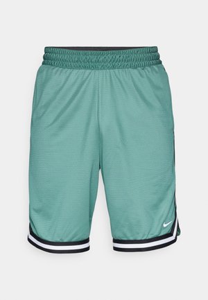 Pantaloni sportivi a rete verdi con una cintura elastica nera, caratterizzati da accenti a strisce bianche e nere all'orlo e un piccolo logo.