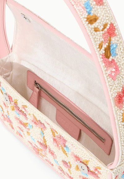 Sac à main avec finition et bandoulière roses, perles brodées à motif floral en rose, bleu et or, ouvert pour montrer l'intérieur beige avec poche zippée.