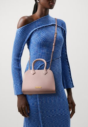 Sac à main en cuir rose avec une forme structurée, des poignées supérieures et une bandoulière amovible. Présente une petite plaque de logo dorée.