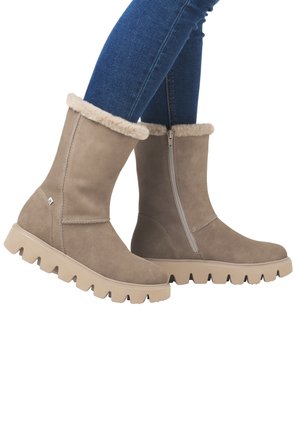 Bottines en daim beige avec une doublure en peluche, dotées d'une fermeture éclair sur le côté et d'une semelle en caoutchouc beige épaisse avec des profondes rainures.