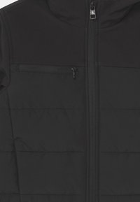 Czarna kurtka o gładkiej, pikowanej fakturze, z zamkiem błyskawicznym z przodu i kieszenią na piersi. Projekt obejmuje kontrastowy materiał na ramionach.