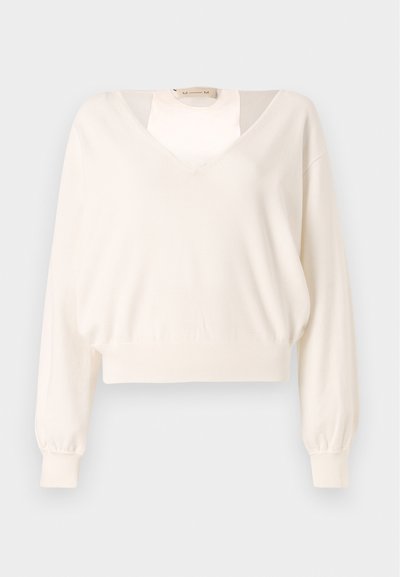 Pull crème à manches longues avec un col en V profond et des poignets et un ourlet côtelés, présenté sur un fond gris clair uni.