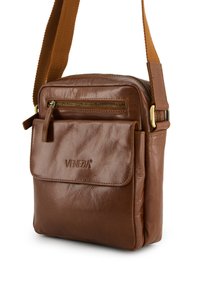 Brun læder crossbody taske med en struktureret finish, der har en frontlomme med klap, lynlås lukning og en holdbar beigefarvet rem.