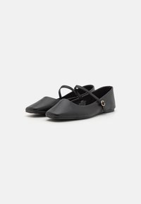 Schwarze flache Schuhe aus glattem Leder. Verfügen über eine spitze Zehenform, zwei Kreuzriemen und eine kleine dekorative Schnalle an der Seite.