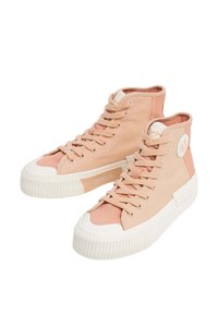 Heledad sneakerid heleda roosa kangast koos valgete kummist aktsentide ja tallaga. Omab ümmargust logo plaastrit ja tekstuuriga soonilise tallaga.