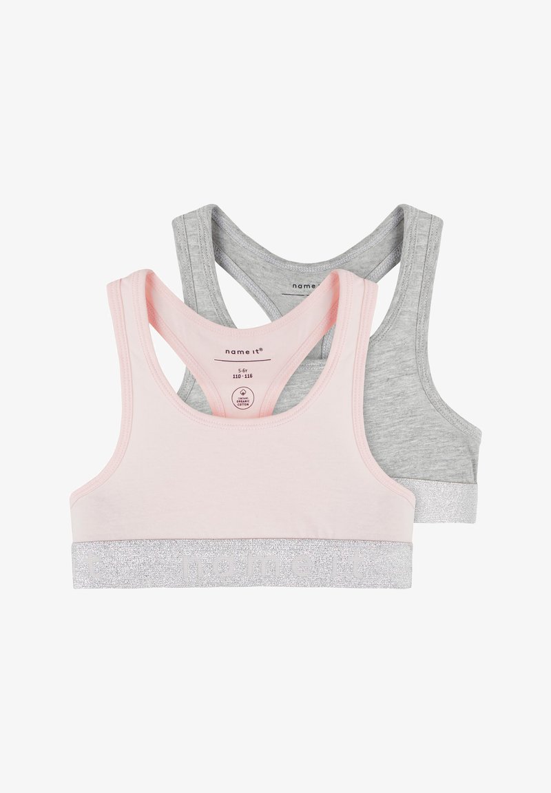 Two crop tops: one in light pink with a silver glitter band, the other in grey with a matching silver band. Both feature a racerback design.