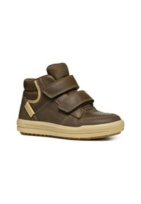 Zapatos de cuero marrón de caña alta con doble tira de Velcro, suela de goma color tostado, punta redondeada y detalles de costura en los laterales.