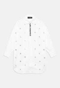 White button-up shirt with long sleeves, featuring scattered silver letter accents and a vertical logo tag on the front. Smooth cotton fabric.