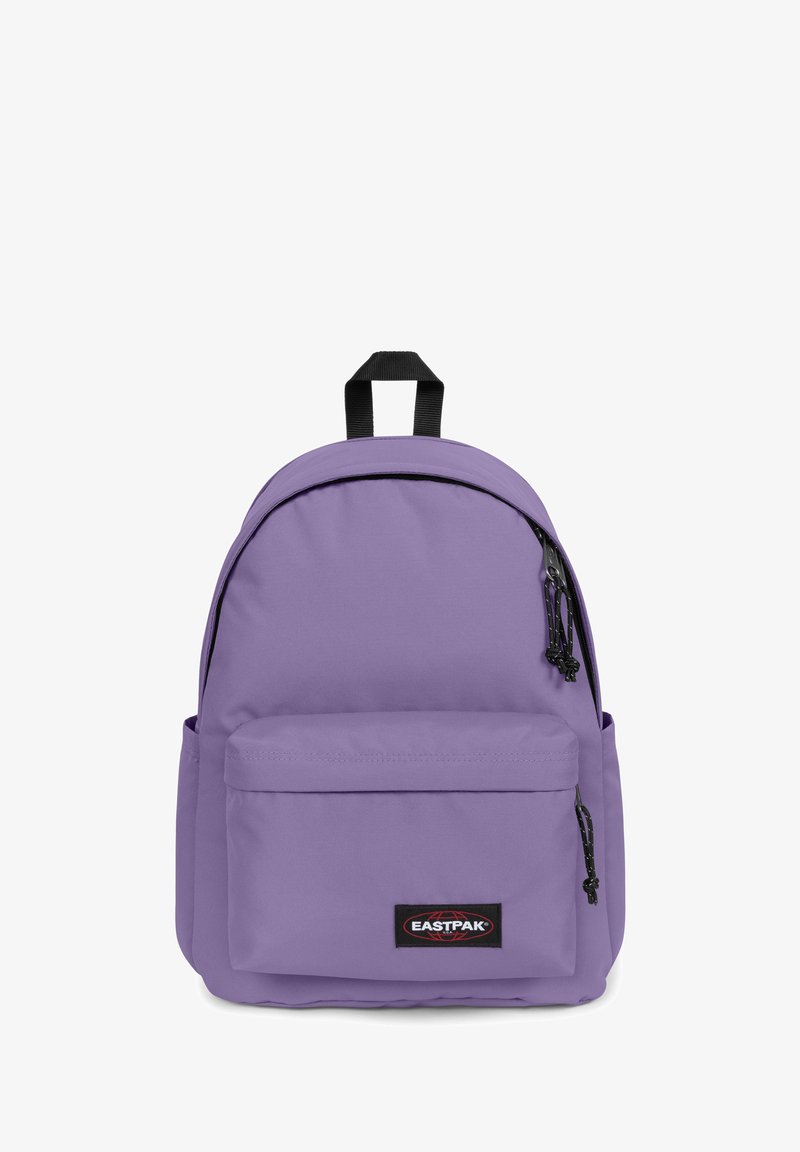 Sac à dos en tissu violet avec une poche zippée à l'avant, des tirettes de fermeture éclair noires et une poignée de transport supérieure. Il est équipé de bretelles rembourrées et présente une texture lisse.