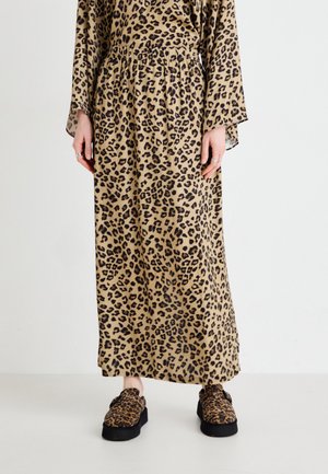 Maxikjole i leopardmønster i beige og sort, lavet af glat stof; parret med matchende leopardmønstrede slip-on sko med sorte såler.