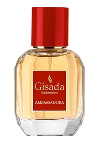 Szklana butelka perfum w ośmiokątnym kształcie, złoty płyn, czerwona nakrętka oraz czerwona etykieta z napisem "Gisada Ambassadora" w złotym kolorze.