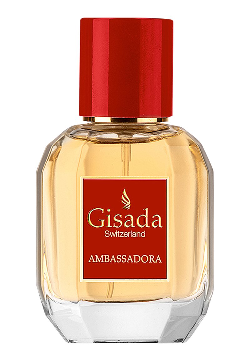 Szklana butelka perfum w ośmiokątnym kształcie, złoty płyn, czerwona nakrętka oraz czerwona etykieta z napisem "Gisada Ambassadora" w złotym kolorze.