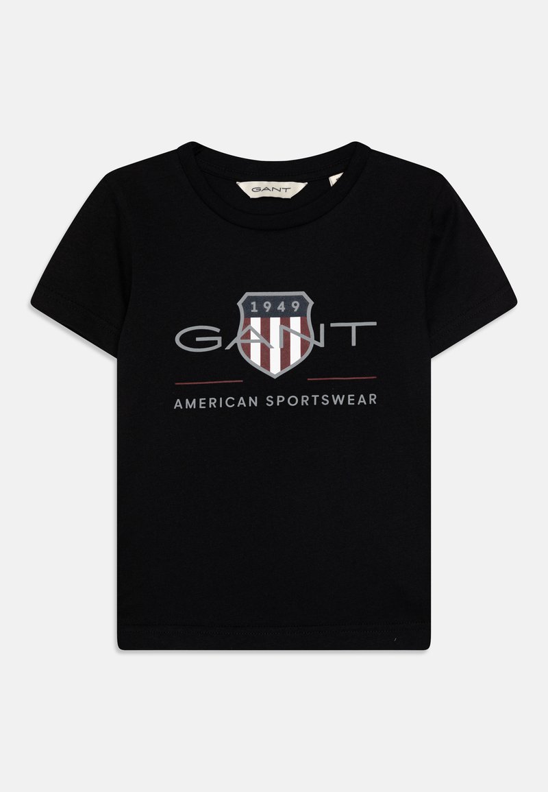Camiseta negra de manga corta hecha de algodón, con un logo de escudo con rayas rojas, la palabra "GANT" y "AMERICAN SPORTSWEAR" debajo.