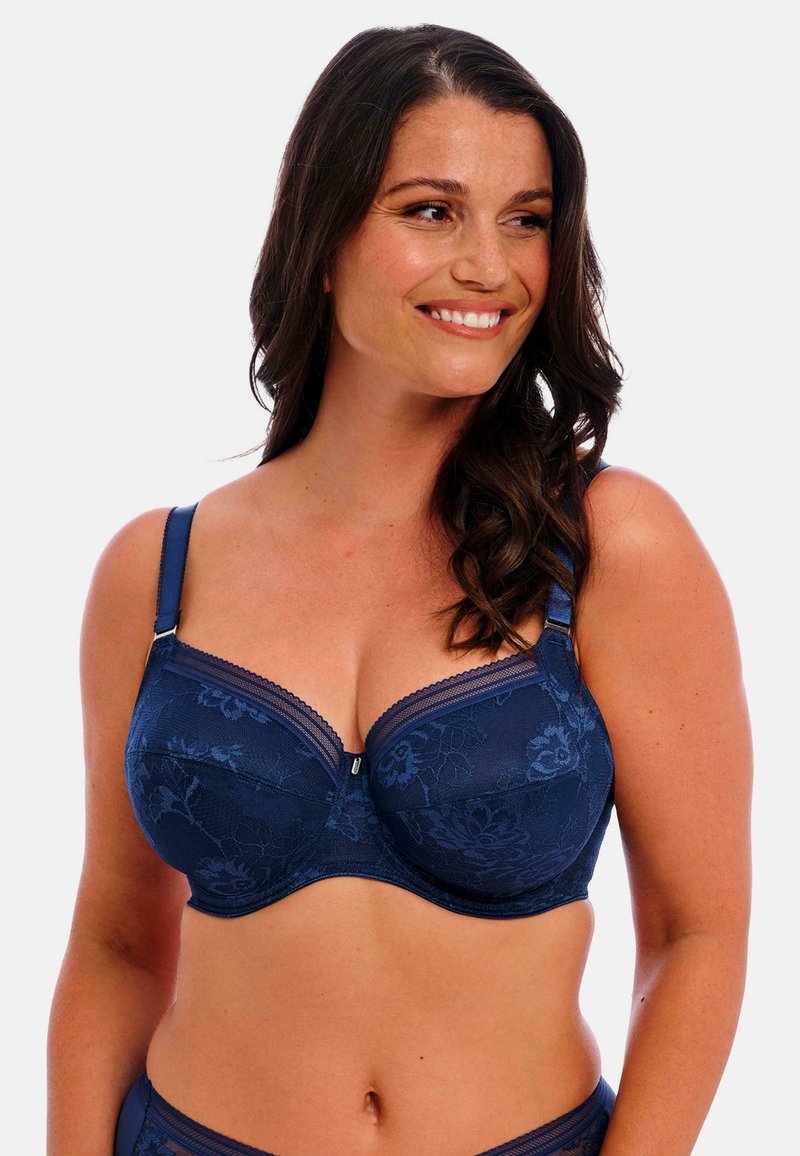 Navyblauwe kanten beha met bloemenpatroon, onderbroken ondersteuning, verstelbare bandjes en decoratieve rand langs de cupranden. Zachte textuur.