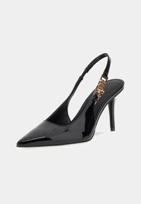 Pumps slingback in vernice nera, con punta affilata, tacco alto sottile e un dettaglio in metallo dorato sulla striscia. Texture liscia e lucida.