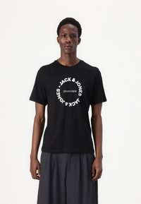 Black cotton t-shirt featuring white circular text with "JACK & JONES" and "DENIM CREW" prominently displayed on the front.