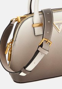 Petit sac à main en dégradé de matériaux texturés beige et gris, doté de ferrures dorées, de deux poignées supérieures et d'une bandoulière amovible.