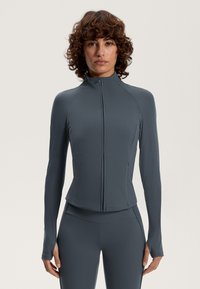 Siva, rebrasta atletska jakna z visokim ovratnikom, sprednjim zadrgo in prilega zasnova. Dolgi rokavi imajo odprtine za palce za izboljšano udobje.