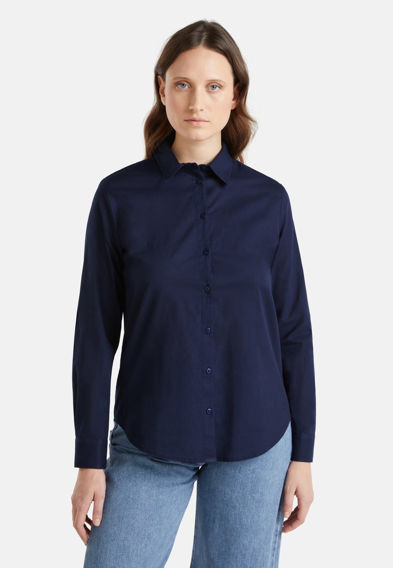 Granatowa bawełniana koszula zapinana na guziki, z ostrym kołnierzykiem, długimi rękawami i zaokrąglonym dołem, z dopasowanymi guzikami i gładką fakturą.