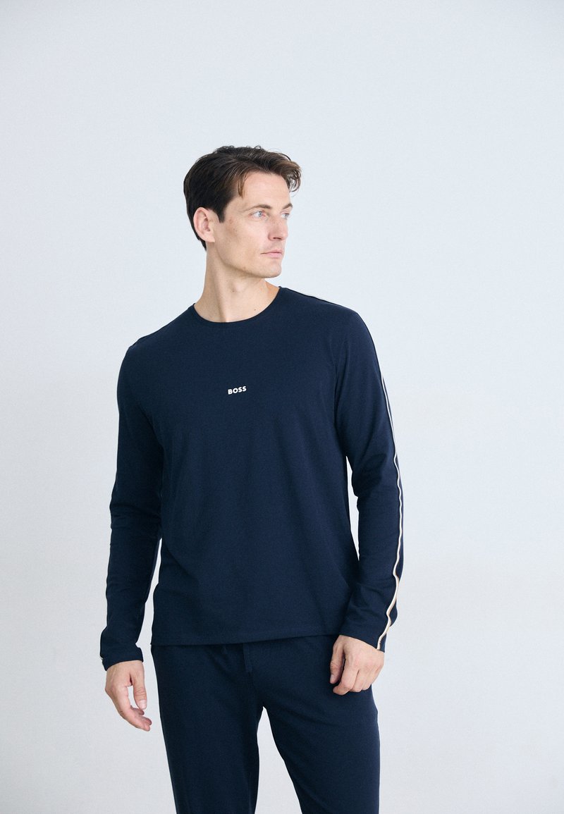 Marineblå langermet skjorte med rund hals og en liten hvit "BOSS"-logo på brystet; har kontrasterende hvite sidestriper.