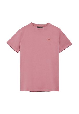T-shirt en coton rose avec des manches courtes, un col rond et un petit patch logo carré sur la poitrine. Texture lisse et design décontracté.