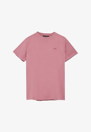 T-shirt en coton rose avec des manches courtes, un col rond et un petit patch logo carré sur la poitrine. Texture lisse et design décontracté.