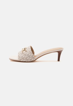 Sandale mule beige à bout ouvert, talon bas marron et large bride à motif avec détail chaîne dorée.