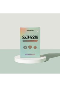 Patches de soins de la peau emballés dans une boîte holographique aux couleurs vert clair, bleu et violet. Trois formes géométriques sur le devant.