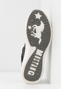 Black athletic shoe outsole with a textured design featuring a unicorn and stars. "MUSTANG" is embossed in white at the heel.