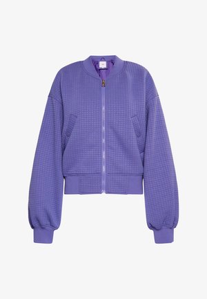 Lilla quiltet bomberjakke med lynlås foran, ribbede manchetter og justerbar kant. Har to sidelommer og rund halsudskæring.
