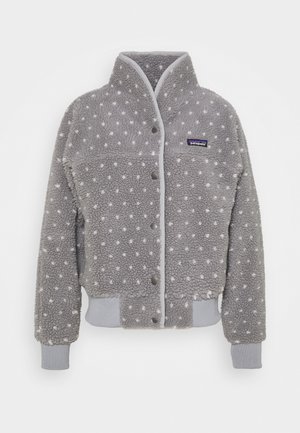 Veste en polaire grise avec des pois blancs, col haut, fermeture à boutons, poignets et ourlet côtelés, arborant un logo Patagonia sur la poitrine.